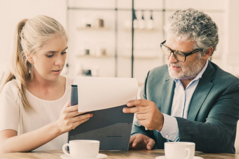 mature legal advisor reading document explaining details young customer 768x512